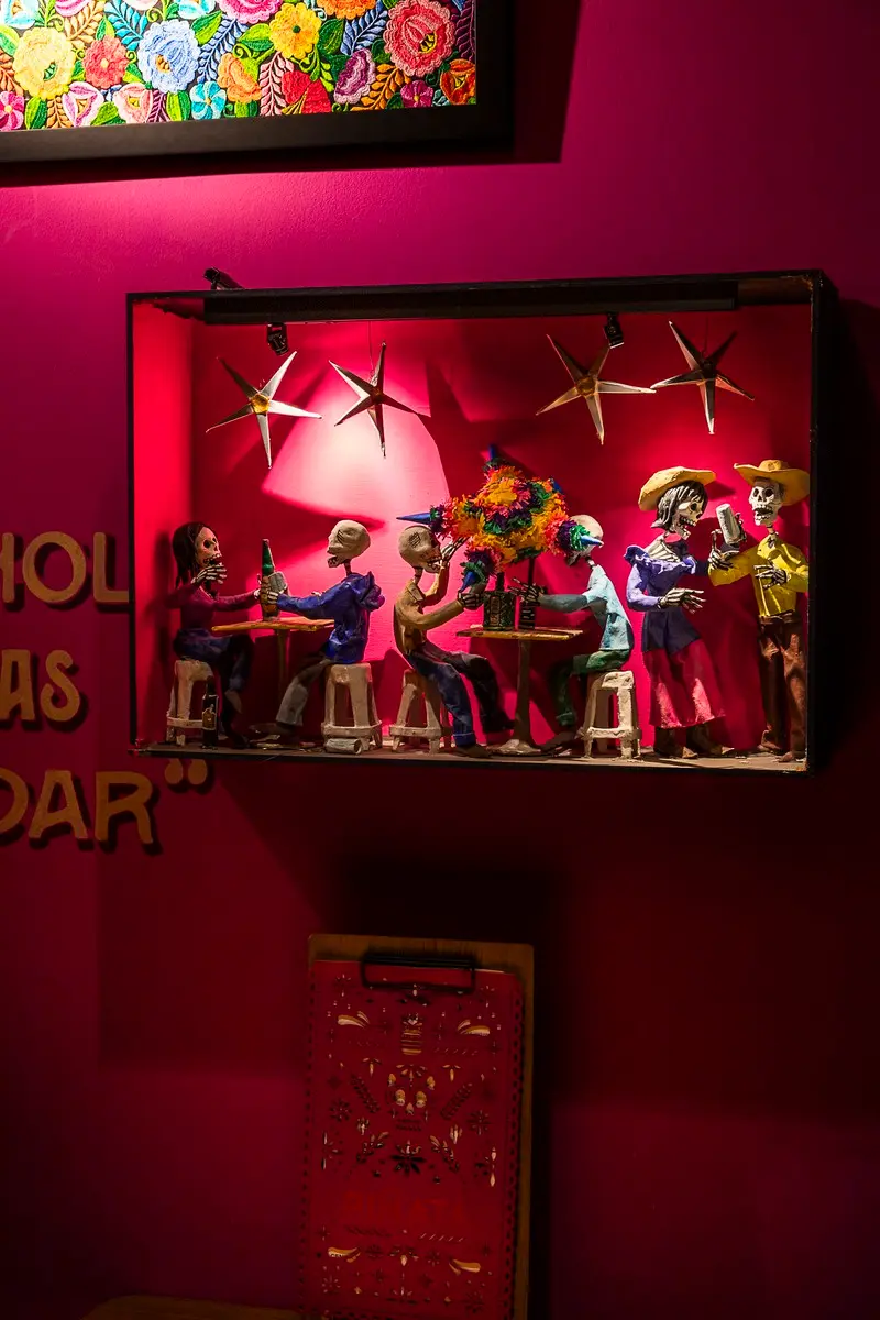 Una de las cajitas de Piñata Cantina con figuras mexicanas iluminadas en rosa