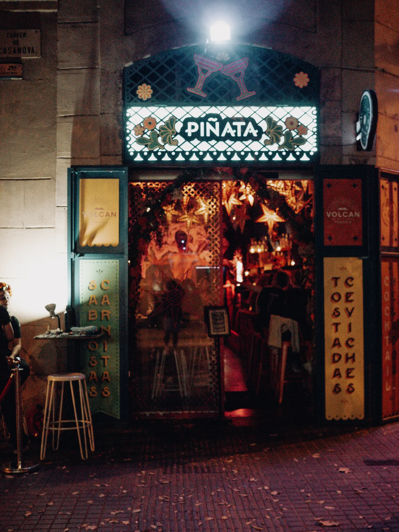 La fachada de Piñata Cantina de noche, con la puerta abierta y las estrellas encendidas dentro
